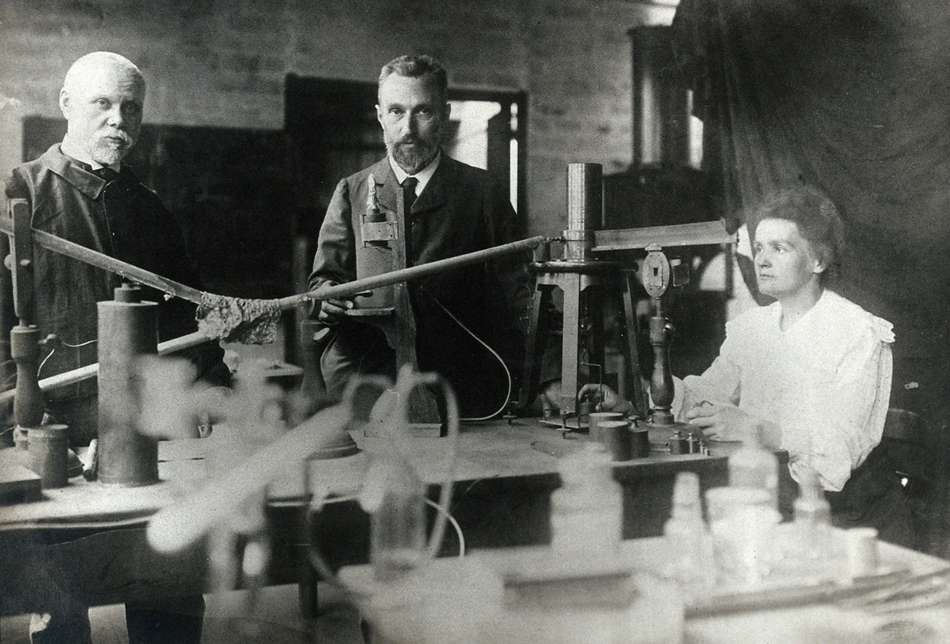 Gustave Bémont, Pierre Curie, & Marie Curie in the laboratory.²